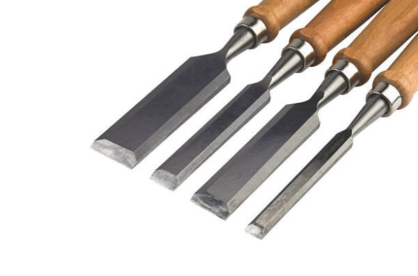 Four chisels of various widths lying on a white background